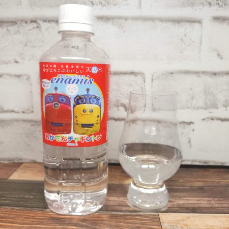 「島根のおいしい天然水 enamis（エナミズ）おかでんチャギントン」とテイスティンググラスの画像