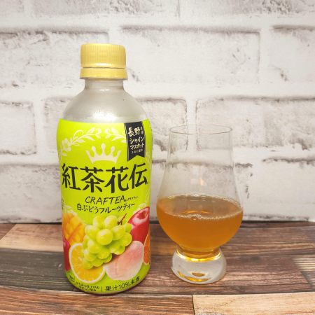 「紅茶花伝クラフティー 白ぶどうフルーツティー」とテイスティンググラスの画像