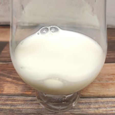 「白バラ牛乳」をテイスティンググラスに注いだ画像