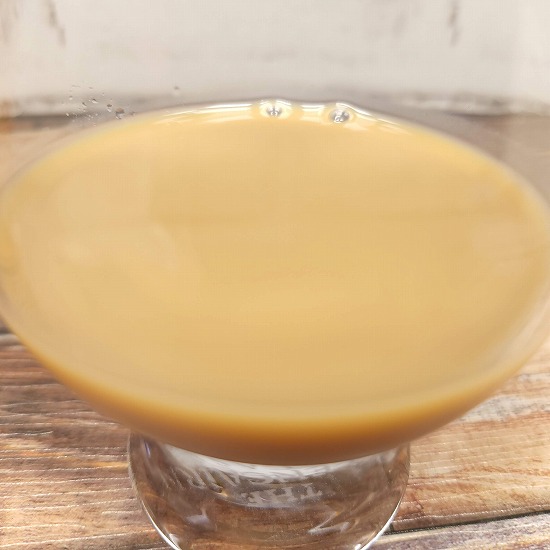 「CREAM de CAFE・贅沢仕立てのミルクティー」をテイスティンググラスに注いだ画像